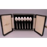 A boxed set of silver gilt white enamel coffee spoons, Birmingham 1949.