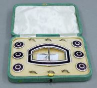 A cased set of enamel decorated silver buckle and buttons. The case 14 cm wide.