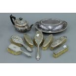 A silver teapot, seven silver backed brushes and a plated entree dish.