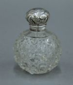 A silver topped cut glass scent bottle. 9.5 cm high.