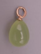 A 14 ct gold mounted jade egg form pendant. 2 cm high.