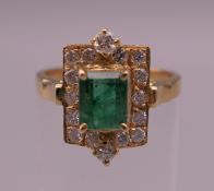 An 18 K gold emerald and diamond ring. Ring size N. 4.5 grammes total weight.