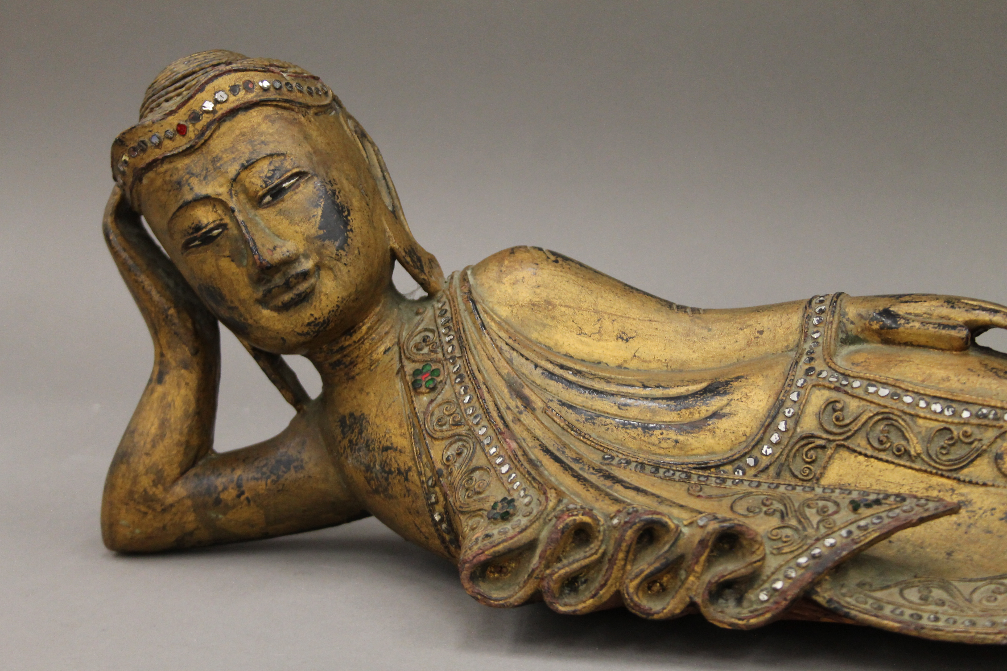 A Burmese carved wood and gilded reclining Buddha with mirrored glass inlay. 57 cm long. - Image 2 of 4