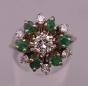 An 18 ct white gold emerald and diamond ring. Ring size M. 5.7 grammes total weight.