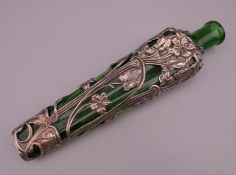 A silver clad green glass scent bottle with Art Nouveau stylized flowers. 20 cm high.