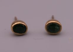 A pair of emerald ear studs (one lacking back). 4 mm high.