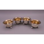 Four Victorian circular silver salt cellars, each on three ball feet and gilded interiors,