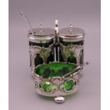 A silver cruet set with green glass liners and two matched spoons. 7.5 cm high.