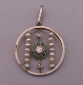 An Edwardian emerald, pearl, enamel and diamond openwork pendant. 2 cm high.