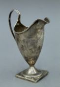 A George III silver pedestal helmet cream jug, makers mark IB, hallmarked London 1791. 13.5 cm high.