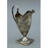 A George III silver pedestal helmet cream jug, makers mark IB, hallmarked London 1791. 13.5 cm high.