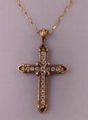 A cross form pendant mounted on a 9 ct gold chain. The pendant 3 cm high.