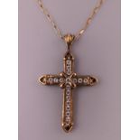 A cross form pendant mounted on a 9 ct gold chain. The pendant 3 cm high.