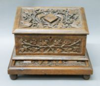 A Victorian box carved with oak leaves; together with a similarly carved wooden stand.