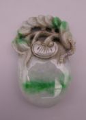 A jade peach and money form pendant. 8.5 cm high.