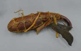 A tribal Witch Doctor gourd, sinew bound with animal and bone attachments. 43 cm long.