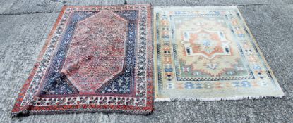 A red ground wool rug and another rug.
