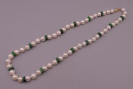 A 14 ct gold clasped pearl and jade necklace. 46 cm long.