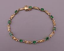 A 14 K gold emerald and diamond bracelet. 18 cm long. 7.4 grammes total weight.