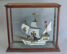 A late 19th/early 20th century model of a galleon in a glass lift up case. The case 70 cm wide.