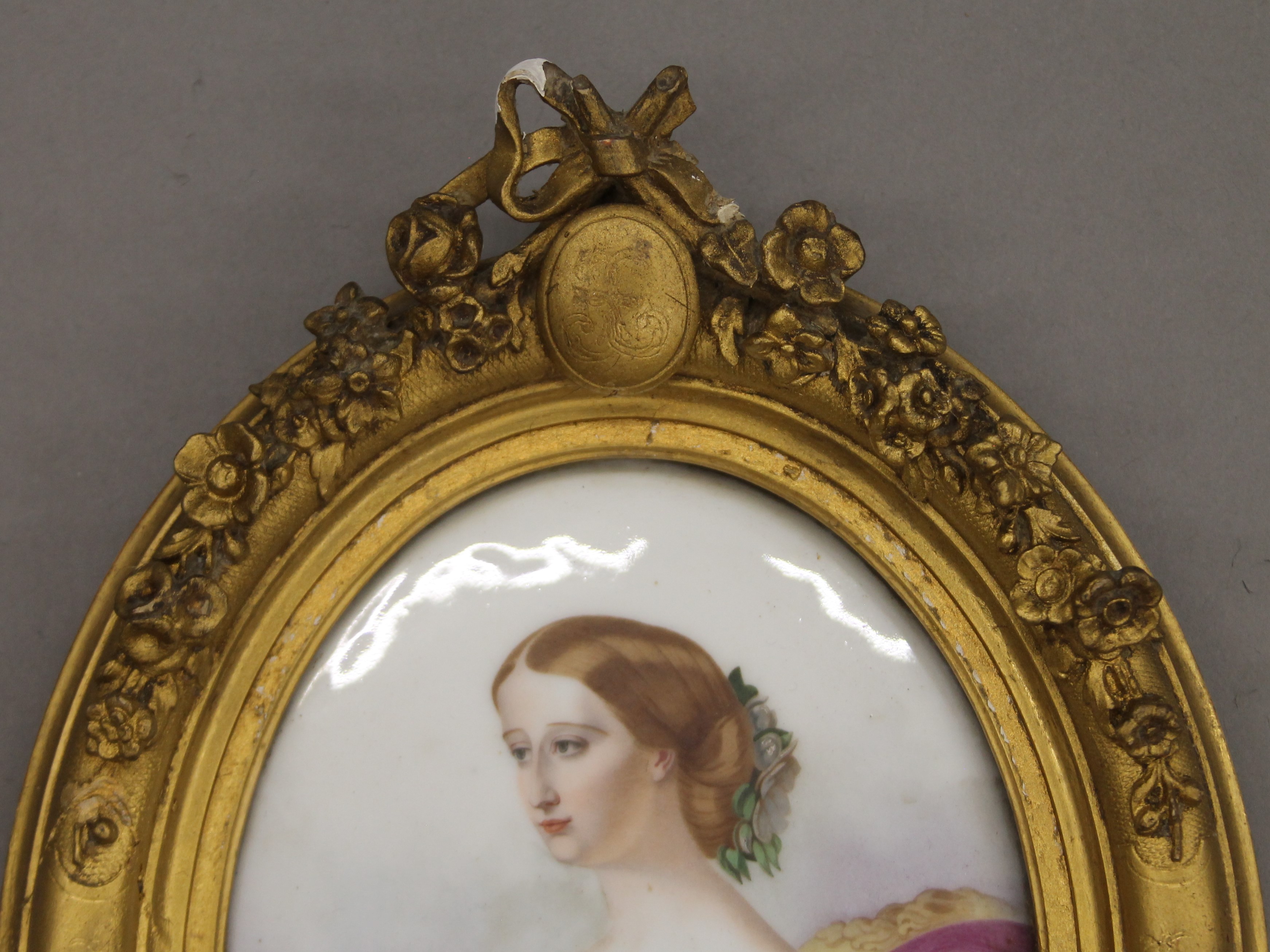 A 19th century Continental plaque painted with a seated lady, housed in an oval gilt frame. - Image 2 of 2