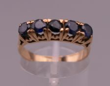 An unmarked 18 ct gold five stone sapphire ring. Ring size M/N. 3.4 grammes total weight.