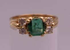 An 18 K gold square emerald and four diamond ring. Ring size N. 4 grammes total weight.
