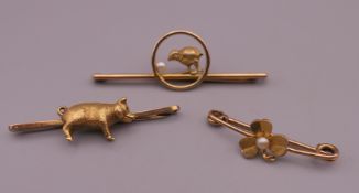 Three 9 ct gold bar brooches, one centred with a pig. The largest 5 cm long. 13.