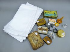 A quantity of miscellaneous items, including vintage tins, linen table cloths, etc.