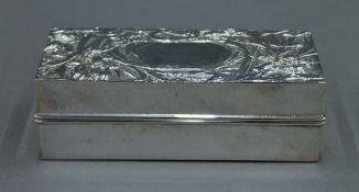 A silver lidded box, the lid decorated with stylized flowers. 14 cm long. 7.5 troy ounces.