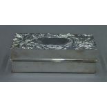 A silver lidded box, the lid decorated with stylized flowers. 14 cm long. 7.5 troy ounces.