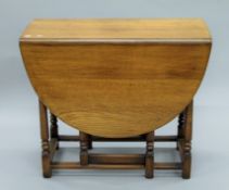 An oak gate leg table, a carved armchair and another chair. The former 89 cm long.