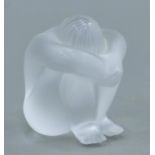 A Lalique glass model of a nude figure, signed Lalique R France. 6 cm high.