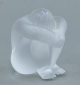 A Lalique glass model of a nude figure, signed Lalique R France. 6 cm high.