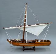 A model of a single masted boat. 60 cm long.