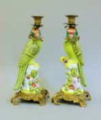 A pair of metal mounted porcelain parrot form candlesticks. 35 cm high.