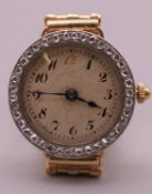 An 18 ct gold cased wristwatch with diamond set bezel with a 9 ct gold bracelet. 2 cm diameter. 26.