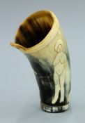 A primitively carved 19th century horn cup, a nude female to one side and a horse to the other.