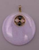 A 14 ct gold mounted lapiz and lavender jade pendant. 4.5 cm diameter.