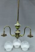 A three-branch brass chandelier with shades. 99 cm high.