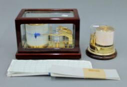 Two Barigo barographs with paper graphs. The largest 26 cm wide.