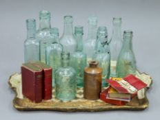 A collection of vintage bottles, playing cards and a vintage tray.