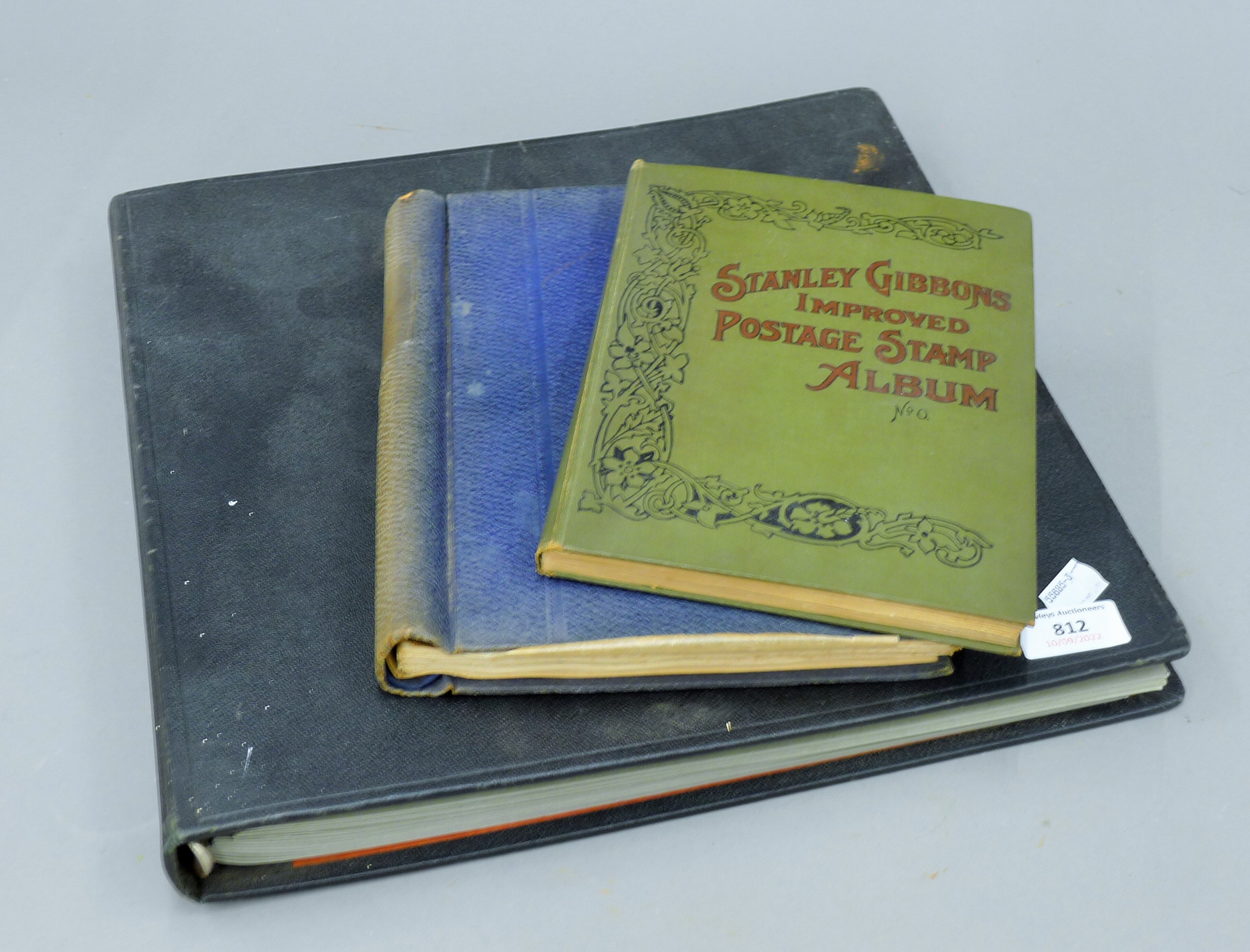 Two stamp albums and a postcard album.