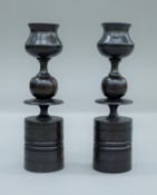 Two turned wooden candlesticks. 21 cm high.