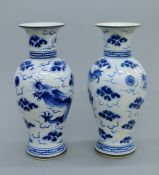 A pair of Chinese blue and white porcelain vases, each decorated with a dragon. 33 cm high.