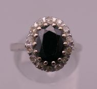 An 18 ct white gold sapphire and diamond cluster ring. Ring size P. 4.5 grammes total weight.