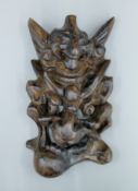 An Eastern carved grotesque wall mask. 31 cm high.