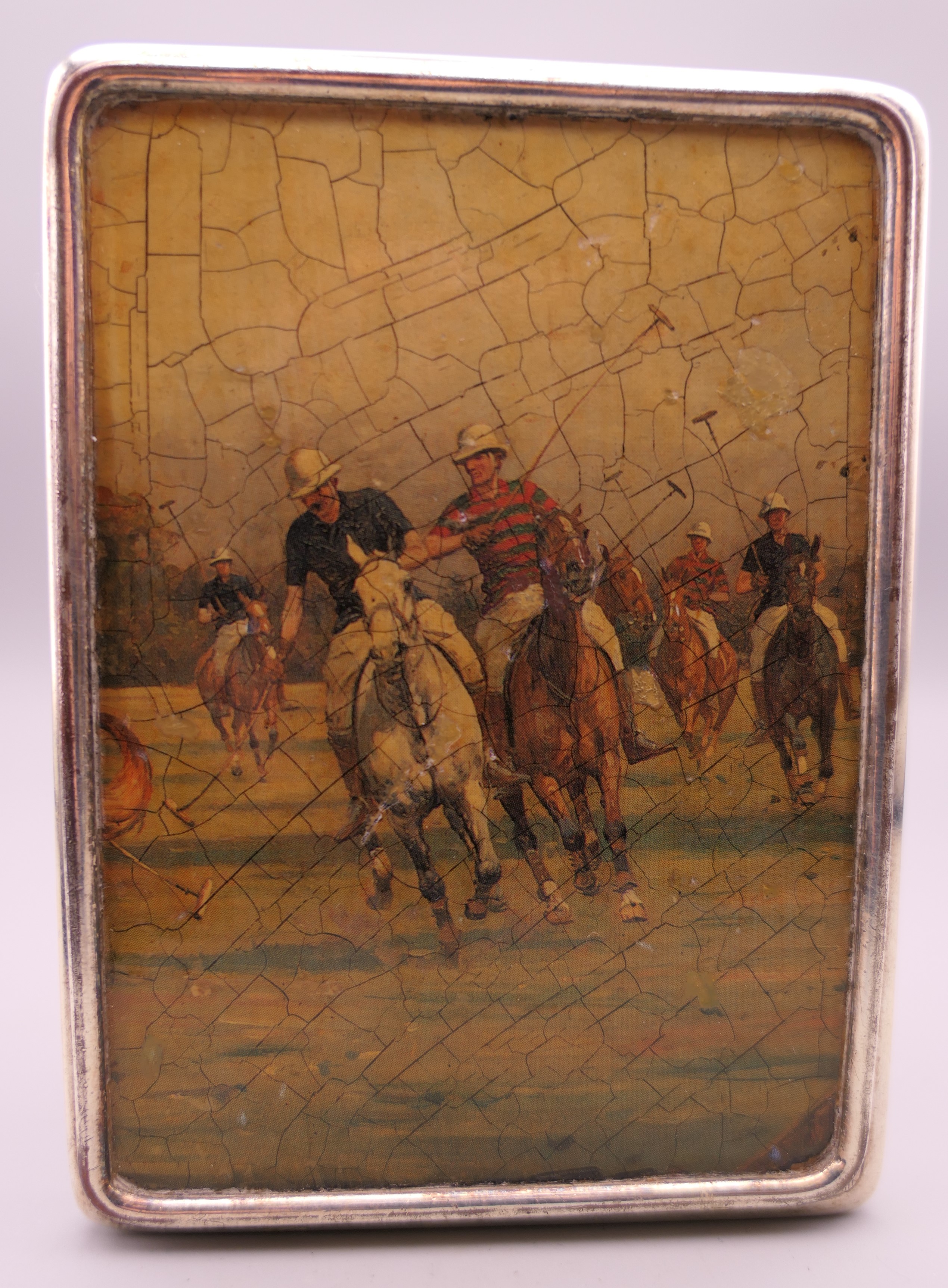 A silver cigarette case decorated with polo scenes. 8.5 cm wide. 219.2 grammes total weight.