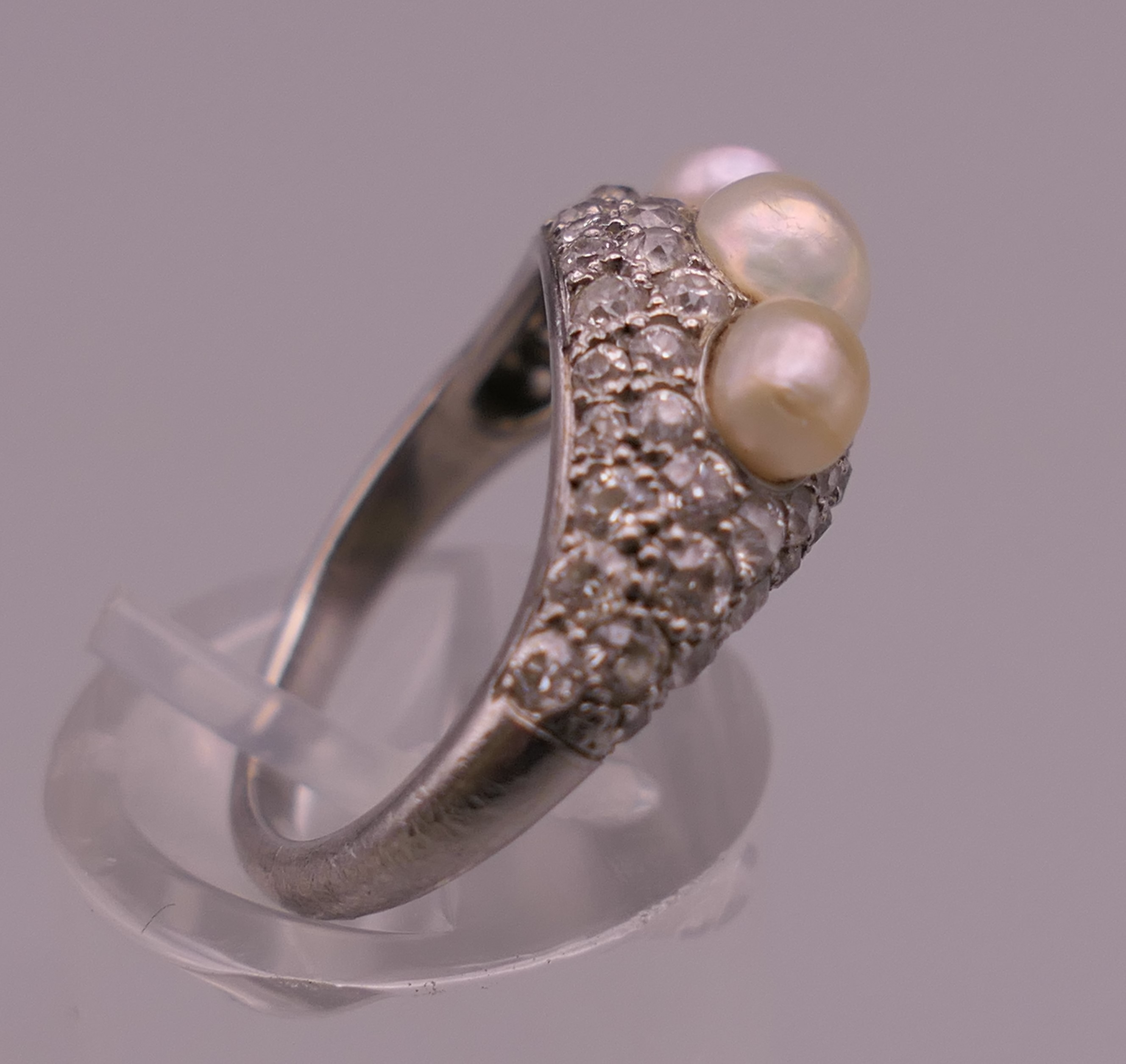 An unmarked white gold or platinum diamond and pearl ring. Ring size I/J. 5.6 grammes total weight. - Image 2 of 12