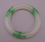 A two-tone jade bangle. 6 cm interior diameter.